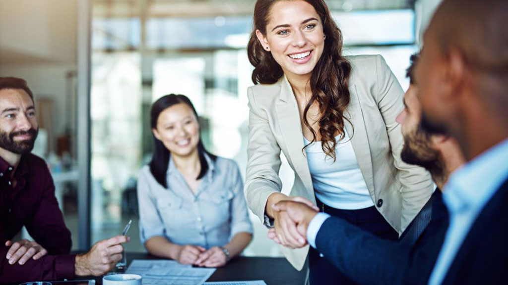 Professionnel accueillant des participants à l'entrée d'un centre de formation moderne